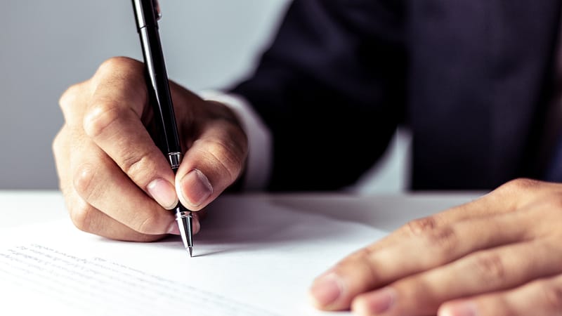 Businessman signing a document in office