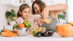 Madre e hija en la cocina con verduras
