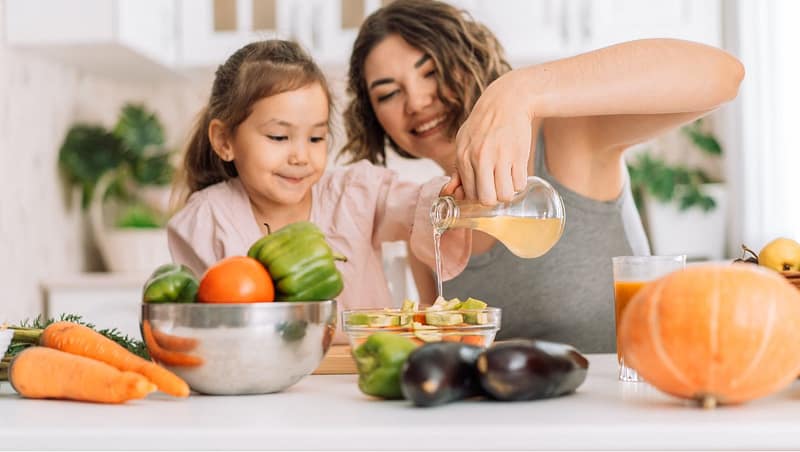 Madre e hija en la cocina con verduras